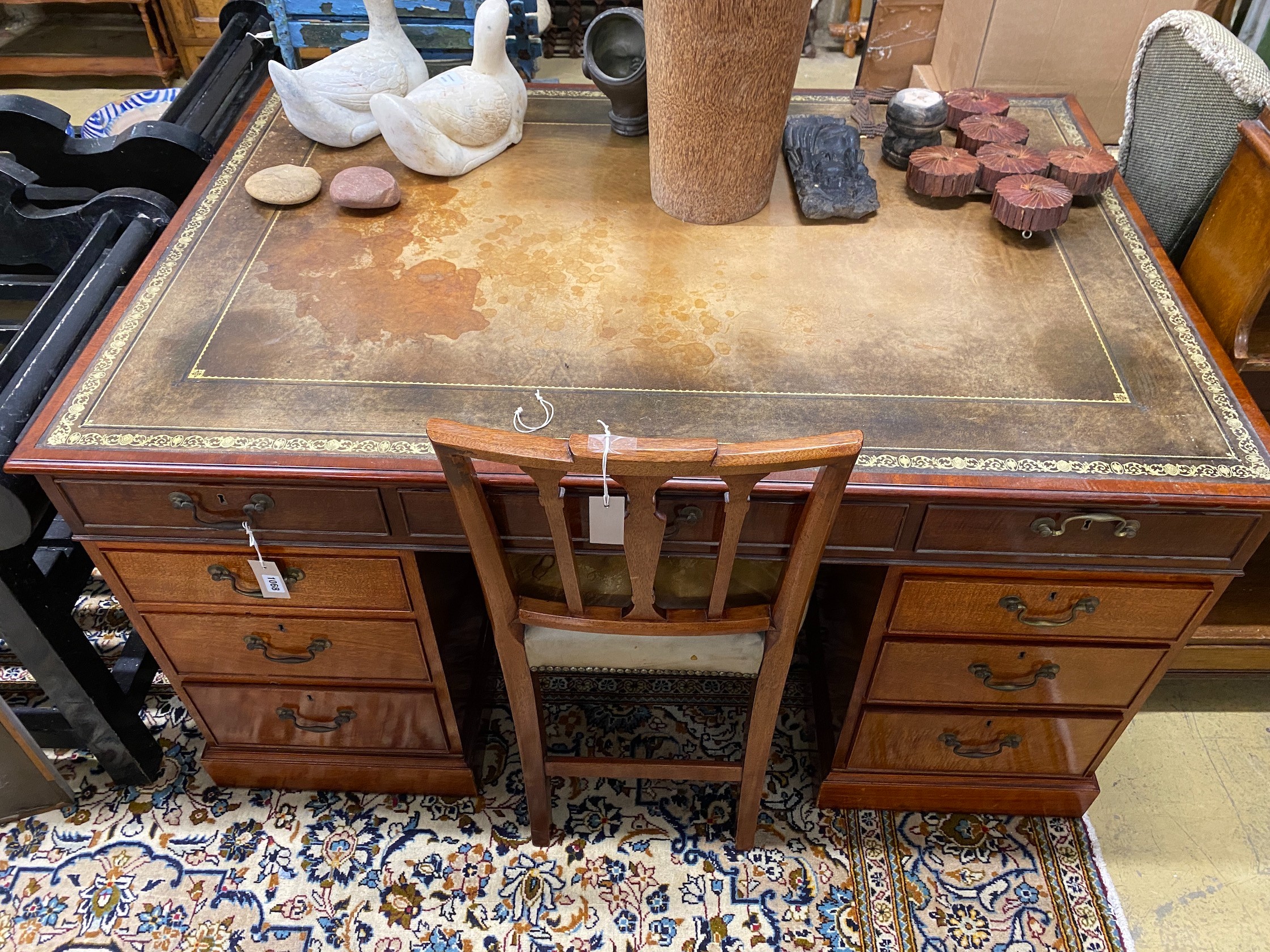 A George III style mahogany pedestal partner's desk by William Tillman, width 142cm, depth 96cm, height 77cm together with a Sheraton style mahogany and tan leather chair, (2)